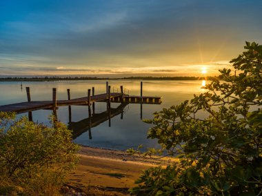 Şafak vakti ahşap iskelede göl manzarası