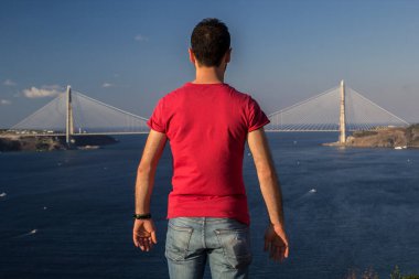 Denizde köprü arayan bir adamın arka görüntüsü
