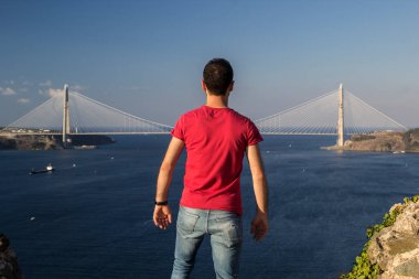 Denizde köprü arayan bir adamın arka görüntüsü