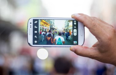 BEYOGLU, İSTANBUL, TURKEY, 18 Temmuz 2015: Karma Nüfus. Taksim Caddesi 'nde kalabalık var. Geçit alayının fotoğraflarını cep telefonuyla çekiyor..