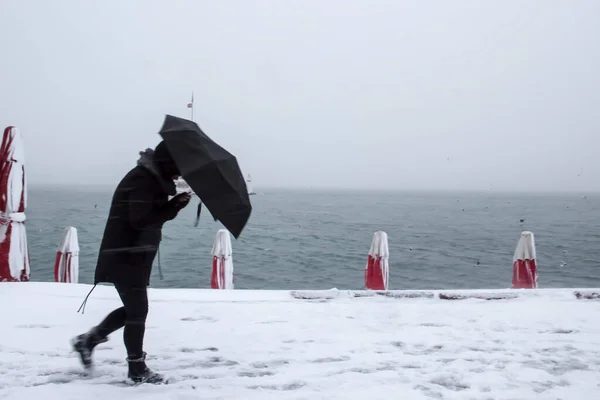 乙女の塔 Kiz Kulesi 雪と冬と人々はイスタンブール トルコから傘で歩いています ストック画像