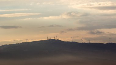 Hava karardığında rüzgar türbinleri ve sis