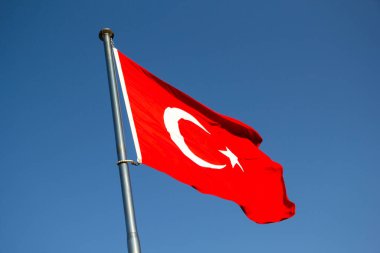 Türk bayrağı mavi gökyüzünde dalgalanıyor, Türkiye. Bayrak beyaz ay ve kırmızı zemin üzerinde yıldız. Kırmızı renk şehit kanını sembolize ediyor. 29 Ekim (Cumhuriyet Günü)