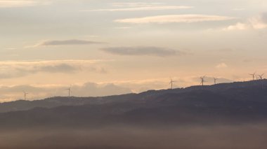 Hava karardığında rüzgar türbinleri ve sis