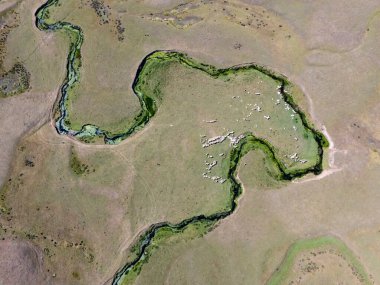 Türkiye 'nin Ordu kentindeki Persembe Platosu' nda, sarmal kanatlıların yukarıdan aşağı havadan görünüşü. Yılan nehri yeşil bir vadi boyunca akar ve kıyılarında geleneksel evler bulunur. Karadeniz dağlarının şaşırtıcı doğal deseni ve coğrafi harikası..