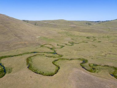 Ordu, Türkiye 'deki Persembe Platosu' nda kıvrımlı nehir manzarası görülüyor. Bereketli yeşil bir vadinin manzarası berrak mavi gökyüzünün altında yılan suyu kıvrımları var. Karadeniz dağları ve Anadolu çöllerinin eşsiz bir doğal oluşumu.