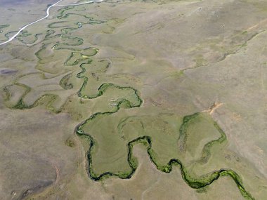 Ordu 'nun Persembe Platosu' ndaki sisli dağlar ve çam ormanlarının havadan görünüşü. Geleneksel dağlık evlerle dolu yemyeşil tepelerin üzerinde süzülen sis. Karadeniz bölgesinin dramatik ve karamsar doğal manzarası bulutlu bir yaz gökyüzü altında.