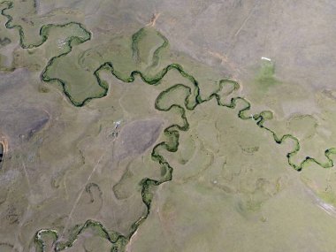 Türkiye 'nin Ordu kentindeki Persembe Platosu' nda havadan seyyar yılan manzarası. Geleneksel köy evleri olan yemyeşil bir vadiden akan dolambaçlı bir nehir. Açık bir yaz gökyüzü altında Karadeniz dağlarının çarpıcı coğrafi örüntüsü.