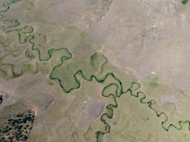 Türkiye 'nin Ordu kentindeki Persembe Platosu' nda havadan seyyar yılan manzarası. Geleneksel köy evleri olan yemyeşil bir vadiden akan dolambaçlı bir nehir. Açık bir yaz gökyüzü altında Karadeniz dağlarının çarpıcı coğrafi örüntüsü.