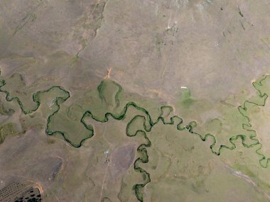 Türkiye 'nin Ordu kentindeki Persembe Platosu' nda havadan seyyar yılan manzarası. Geleneksel köy evleri olan yemyeşil bir vadiden akan dolambaçlı bir nehir. Açık bir yaz gökyüzü altında Karadeniz dağlarının çarpıcı coğrafi örüntüsü.