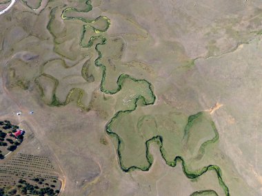 Türkiye 'nin Ordu kentindeki Persembe Platosu' nda havadan seyyar yılan manzarası. Dolambaçlı bir nehir yeşil vadi boyunca karmaşık doğal desenler yaratır. Açık bir yaz gökyüzü altında Karadeniz dağlarının çarpıcı coğrafi harikası.