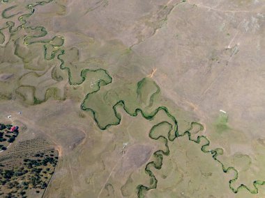 Türkiye 'nin Ordu kentindeki Persembe Platosu' nda havadan seyyar yılan manzarası. Dolambaçlı bir nehir yeşil vadi boyunca karmaşık doğal desenler yaratır. Açık bir yaz gökyüzü altında Karadeniz dağlarının çarpıcı coğrafi harikası.