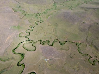 Türkiye 'nin Ordu kentindeki Persembe Platosu' nda yılan avcılarının yüksek açılı hava manzarası. Dönen bir nehir engin yeşil vadi boyunca karmaşık doğal desenler yaratır. Açık bir yaz gökyüzü altında Karadeniz dağlarının çarpıcı coğrafi harikası.