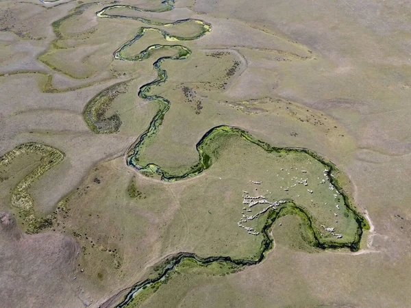 Türkiye 'nin Ordu kentindeki Persembe Platosu' nda dönemeç manzarası. Yamaçlarda geleneksel evleri olan yemyeşil bir vadiden akan manzaralı nehir kıvrımları. Bulutlu bir yaz gökyüzü altında Karadeniz bölgesinin huzurlu doğal manzarası.