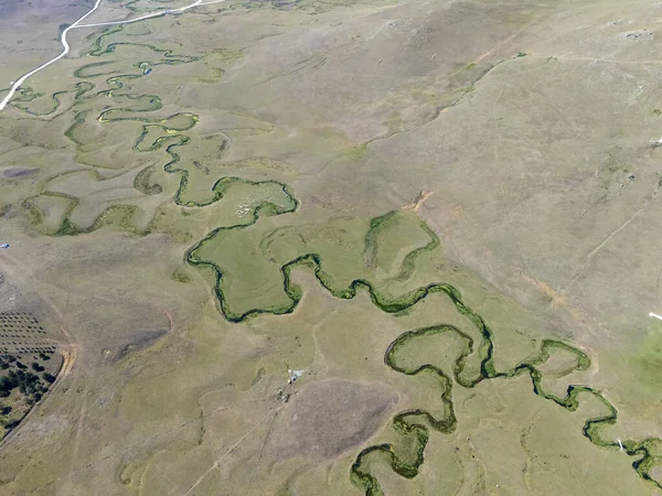 Türkiye 'nin Ordu kentindeki Persembe Platosu' nda sonu gelmeyen dönemeçlerden oluşan hava manzarası. Yeşil ve altın bozkırlarda akan uzun bir yılan nehri. Yüksek açı perspektifi Karadeniz dağ bölgesinin doğal su desenlerini gösteriyor.