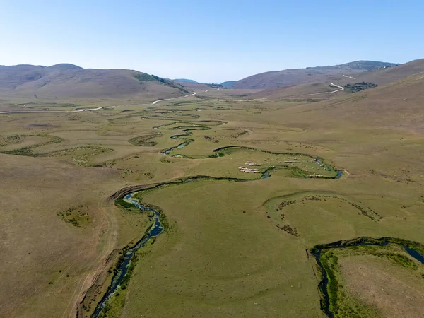 Ordu, Türkiye 'deki Persembe Platosu' ndaki kıvrımlı nehir yataklarının geniş hava manzarası. Temiz mavi gökyüzü altında kıvrılan yılanımsı su kıvrımlı yeşil bir vadinin manzarası. Karadeniz bölgesinin yüksek rakımlı doğal güzelliği ve coğrafi harikası.