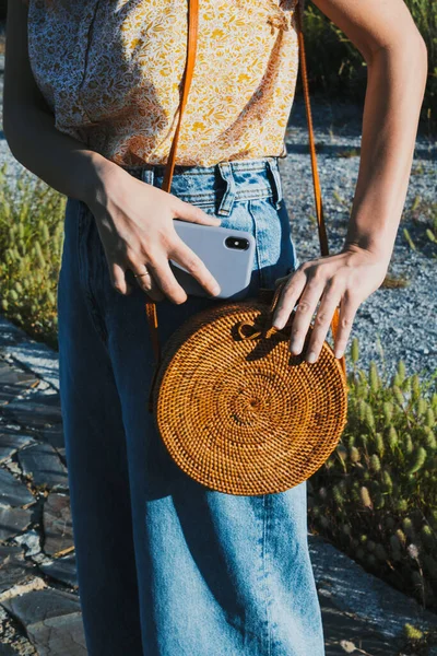 当她在山上度假时 女人的手把她的智能手机放在手提包里 有选择的重点 — 图库照片