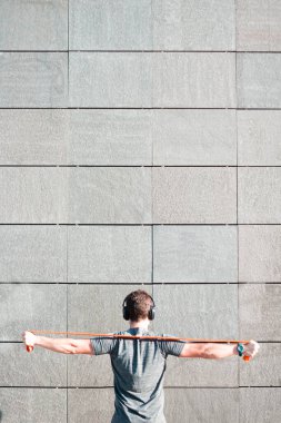 Tıbbi maskeli yakışıklı, esneme bantlı müzik dinliyor. Coronavirüs salgını durumu.
