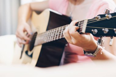 Gitar çalan güzel bir kadın eve odaklanmış..