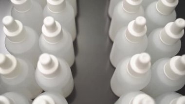 Sıvı dolu bir sürü beyaz şişe. Antiseptik üretimi