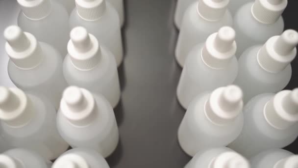 Un montón de botellas blancas llenas de líquido. Fabricación de antisépticos — Vídeo de stock