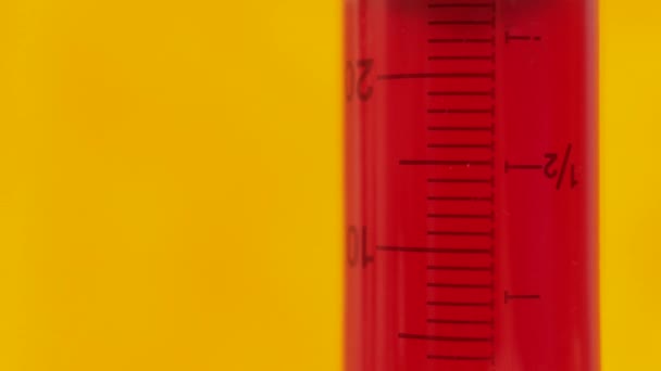 Syringe with red liquid on a yellow background. Medication and Health Care Concept. — Stock Video