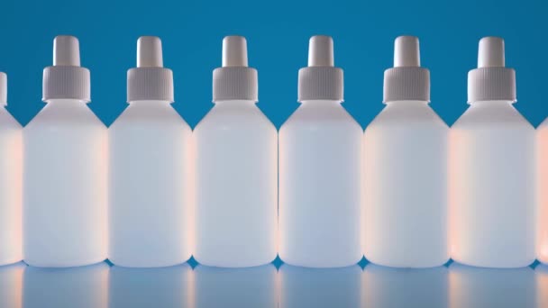 Πολλά λευκά μπουκάλια με υγρό. Απολυμαντικό ή μεσαμέντε σε λευκές φιάλες — Αρχείο Βίντεο