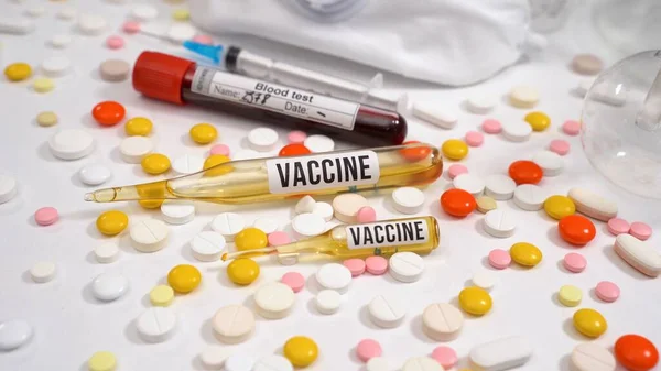 Vacuna lista en ampollas para aplicar. Vacuna, tabletas, ampollas, probeta con análisis de sangre. Medicamento Covid-19. Ampollas inyectables con vacuna — Foto de Stock