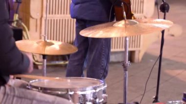Büyük şehrin gece sokağında gitarlı ve davullu sokak müzisyenleri. Bir sokak müzisyeni davul çalar. Sokak rock grubu. Gece şehri