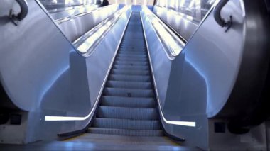 Metrodaki yürüyen merdivenden yukarı çıkıyor. Yürüyen merdivenlerin en üst basamakları. Aşağıdan kamera görüntüsü