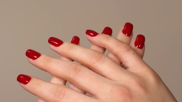 Frauenhände werden gekreuzt. Die Finger mit roter Maniküre sind im Rahmen überkreuzt. Roter Nagellack — Stockvideo