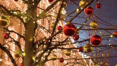 Noel ağacı oyuncakları bulanık, güzel, aydınlık bir evin ön cephesine karşı ağaçta asılı duruyor. Geceleyin Noel Köyü