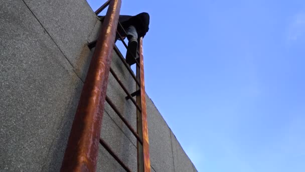 Man is down high rusty steel ladder. Man goes down a Ladder On The Rooftop House — Stock Footage Man is down high rusty steel ladder. Man goes down a Ladder On The Rooftop House Stock Footage