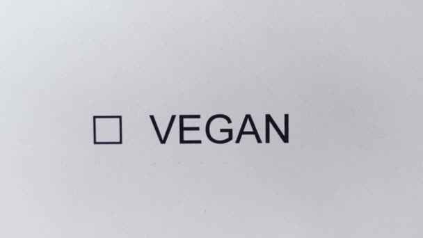 维根- -用笔在白纸上的复选框上画一个勾号.带有题词的标记复选框- VEGAN 。饮食、素食生活方式、生态产品、有机食品. — 图库视频影像
