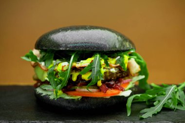 Roka, mozarella, domuz pastırması, sebze ve soğan reçelli hamburgerler.