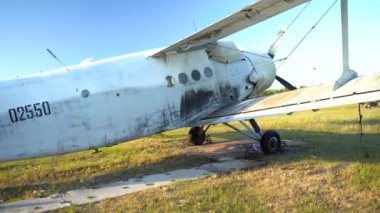 Terk edilmiş bir uçak açık mavi gökyüzüne karşı tarlada duruyor. Küçük pervane düzlemi. 