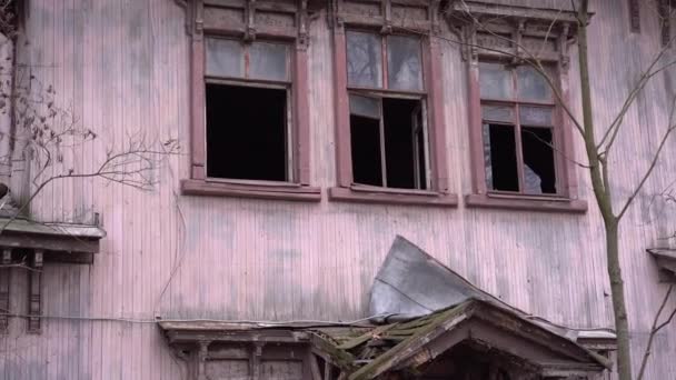 壊れた窓で修理中の古いピンクの家の風化側。木の枝を持つ放棄された古いウィンドウ — ストック動画