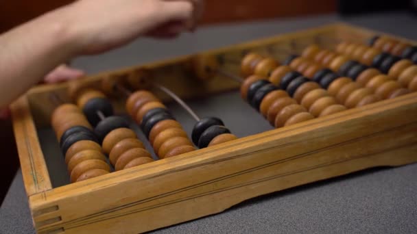 Männliche Hand auf alten hölzernen Scheinen. Handarbeit an alten Abakus-Gleitperlen — Stockvideo