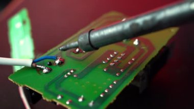 Elektronik tamir. Bir servis çalışanı bir anakart tamir ediyor. Mühendis ya da teknisyen lehim demiriyle elektronik devre kartını tamir ediyor.