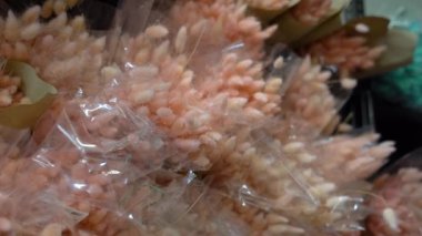 Kurumuş çiçeklerle dolup taşın. Kanarya, lağurus. Çiçek buketleri için süslemeler. Hediye buketi için renkli kulaklarla dolu bir depo. Flourist buket paketleme