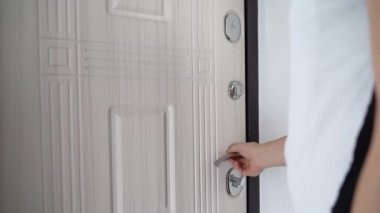 Adam Deadbolt Door 'u açar ve evden çıkar. Çıkıyor ve ön kapıdan giriyor. Kapının kilidini aç ve bir adam odaya giriyor.