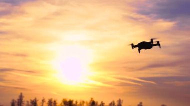 Drone gün batımına doğru uçuyor. Güneş ve Ormanın Üzerindeki Kuadrokopter.