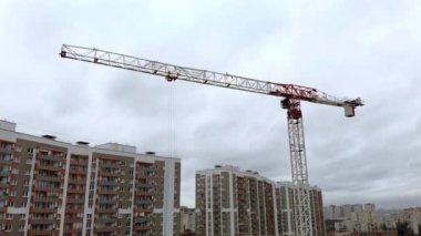 Trolley vinç kolunda hareket ediyor. İnşaat alanının vinçli hava manzarası.