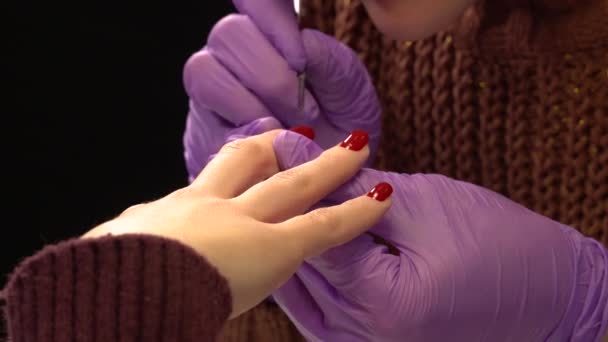Frau im Salon. Frauenhände lackieren Fingernägel mit rotem Nagellack — Stockvideo