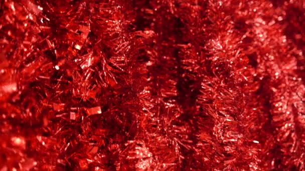 Lentejuelas rojas brillantes esparcidas sobre la superficie. Tinsel rojo brillante de la Navidad. difuminación, enfoque selectivo. Fondo abstracto — Vídeos de Stock