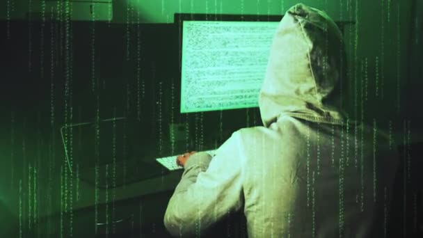 Nastoletni haker w kapturze pracuje na komputerze stacjonarnym. Kod danych na wyświetlaczu — Wideo stockowe