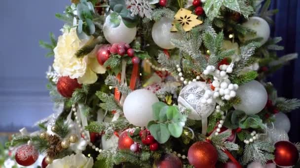 Strălucitoare baubles și lumini agățat pe pomul de Crăciun decorat. Bile roșii și aurii și ghirlande iluminate cu lanterne — Videoclip de stoc