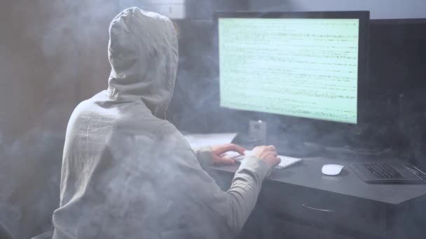 어린 프로그래머 가 컴퓨터 를 연구하고 배경에서 연기를 피운다. 컴퓨터에서 타이핑을 하는 연산자. 방 안의 연기 — 비디오