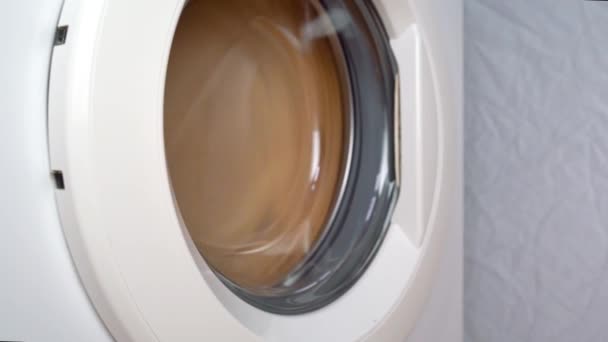 洗衣机把东西弄皱了.侧视。洗衣机在动 — 图库视频影像