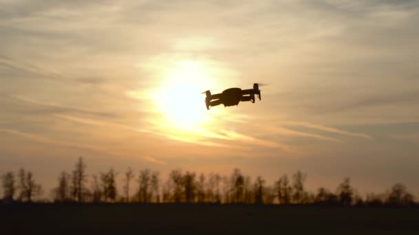 Volar y filmar con un dron. Copter cuádruple con cámara digital. Puesta de sol y bosque — Vídeos de Stock